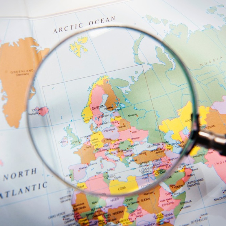 Magnifying glass focusing on a map of Europe